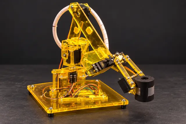 Illustrative reconstruction of the yellow acrylic Arduino robotic arm, showing its articulated structure, gripper, wiring, and complete base